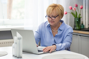 Senior Smiling Woman  working on laptop at home .  online  School teacher  concept .