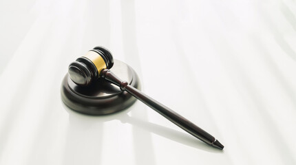 Naklejka premium Wood mallet of the judge, law on the white table.