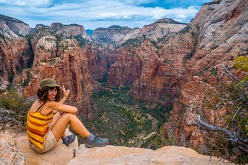 A young woman enjoying the views of Zion from the Angels Landing Trail in Zion National Park, Utah. United States. - obrazy, fototapety, plakaty