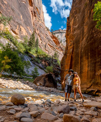A couple inside the canyon of Zion National Park. United States, vertical photo