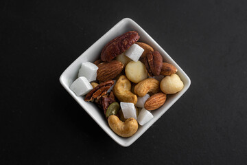 Dried nuts. Pieces of coconut. A healthy snack. Tasty food. Healthy eating. Cashews, almonds and hazelnuts. A mixture of nuts and fruits. Vitamins in food. Nutritious breakfast. Natural ingredients. H