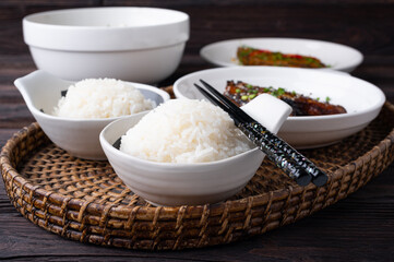 Bowl of boiled rice served on wooden table,