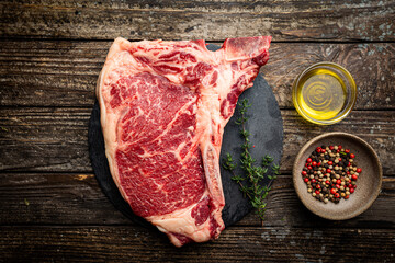 Raw fresh meat T-bone beef Steak on wooden background, top view