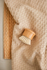Kitchen wooden dishwashing brush and natural muslin towel. Stylish composition made from natural materials. Reusable eco-friendly kitchen products. Zero waste and sustainable plastic free lifestyle. 