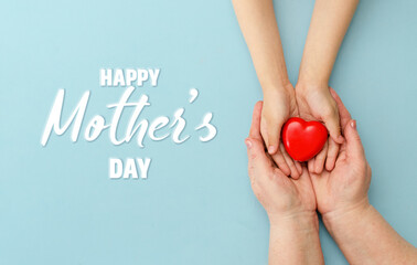 Concept Happy Mother's Day or International Day of Families.Happy women's day.Heart in the hands of daughter and mother on a blue background.I love you.Banner for store.Greeting card. Top view
