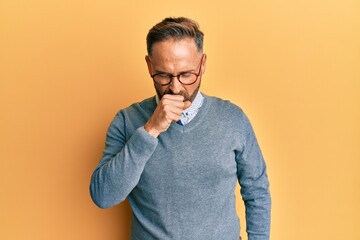 Handsome middle age man wearing glasses feeling unwell and coughing as symptom for cold or bronchitis. health care concept.