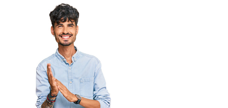 Young hispanic man wearing casual clothes clapping and applauding happy and joyful, smiling proud hands together