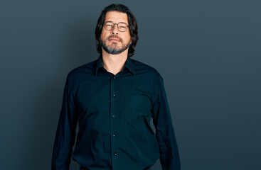 Middle age caucasian man wearing casual clothes and glasses relaxed with serious expression on face. simple and natural looking at the camera.