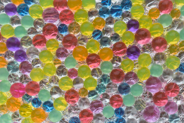 Fototapeta na wymiar Multicolored transparent balls for the backdrop. Background is a silvery surface with highlights. Concept of a festive mood, fun.
