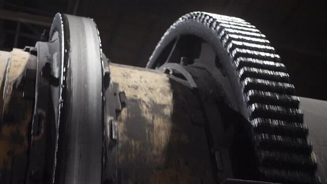 A huge mechanism with large gears quickly rotates.