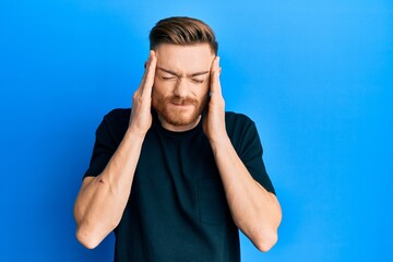 Fototapeta premium Young redhead man wearing casual black t shirt with hand on head, headache because stress. suffering migraine.