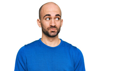 Young hispanic man wearing casual clothes smiling looking to the side and staring away thinking.