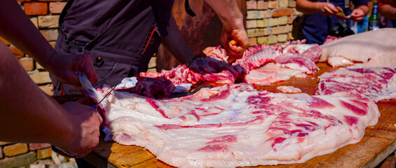 Butcher is cutting, processing fresh meat