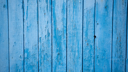 Fototapeta na wymiar Aged blue planks with peeled paint. Blue background. Close-up. Copy space. Defocus.