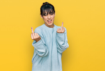Young hispanic woman wearing casual clothes showing middle finger doing fuck you bad expression,...