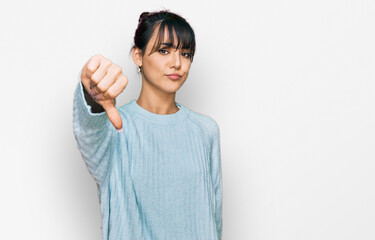 Young hispanic woman wearing casual clothes looking unhappy and angry showing rejection and negative with thumbs down gesture. bad expression.