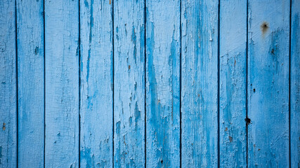 Aged blue planks with peeled paint. Blue background. Close-up. Copy space. Defocus.