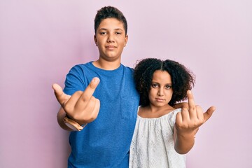 Young hispanic family of brother and sister wearing casual clothes together showing middle finger,...