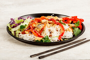 Japchae, Korean glass noodle stir fry. Korean glass japche noodles with stewed chicken with sesame vegetables and sauce on a white background.  Top view. Japchae Asian cuisine. Funchose