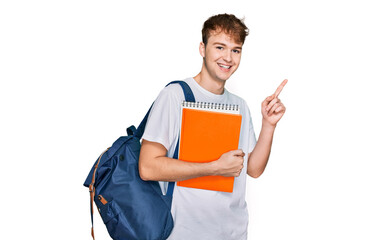 Young caucasian man wearing student backpack and holding books surprised with an idea or question pointing finger with happy face, number one