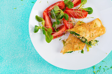 Omelette rolls on a plate. Homemade fried omelet rolls with chopped greens. Healthy low carb recipe. Top view, above