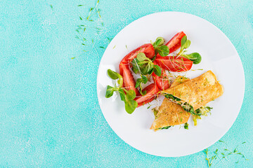 Omelette rolls on a plate. Homemade fried omelet rolls with chopped greens. Healthy low carb recipe. Top view, above