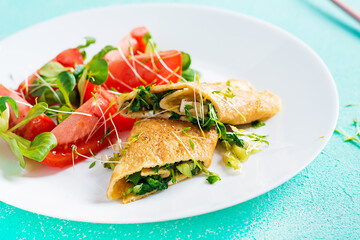 Omelette rolls on a plate. Homemade fried omelet rolls with chopped greens. Healthy low carb recipe.