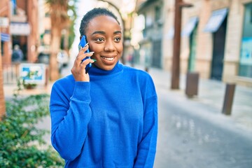 Young african american woman smiling happy talking on the smartphone at the city.