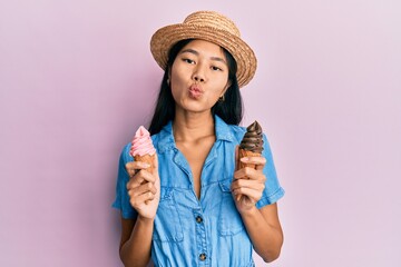 Young chinese woman wearing summer style holding ice cream looking at the camera blowing a kiss being lovely and sexy. love expression.