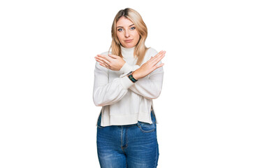 Young caucasian woman wearing casual winter sweater rejection expression crossing arms and palms doing negative sign, angry face