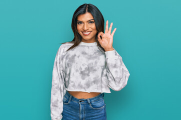 Young latin transsexual transgender woman wearing casual clothes smiling positive doing ok sign with hand and fingers. successful expression.