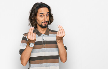 Young hispanic man wearing casual clothes doing money gesture with hands, asking for salary...