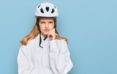Beautiful young caucasian girl wearing bike helmet serious face thinking about question with hand...