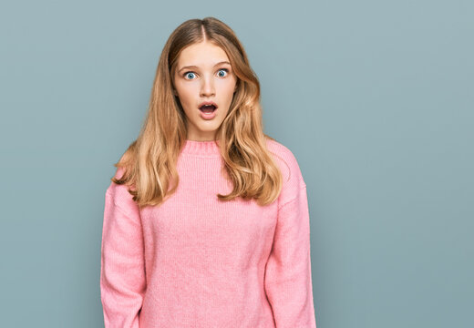 Beautiful young caucasian girl wearing casual winter sweater afraid and shocked with surprise expression, fear and excited face.