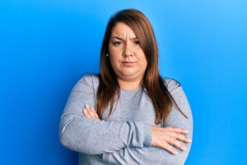 Beautiful brunette plus size woman wearing casual clothes skeptic and nervous, disapproving expression on face with crossed arms. negative person.