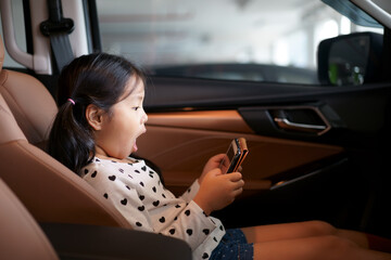 Asian child or kid girl enjoy excited learn or play and watching computer tablet or study online to...