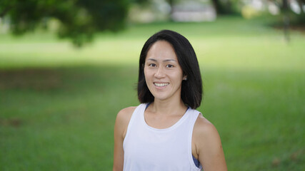 Asian chinese woman smiling sweetly outdoors garden active sporty