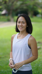 Asian chinese woman smiling sweetly outdoors garden active sporty holding mask