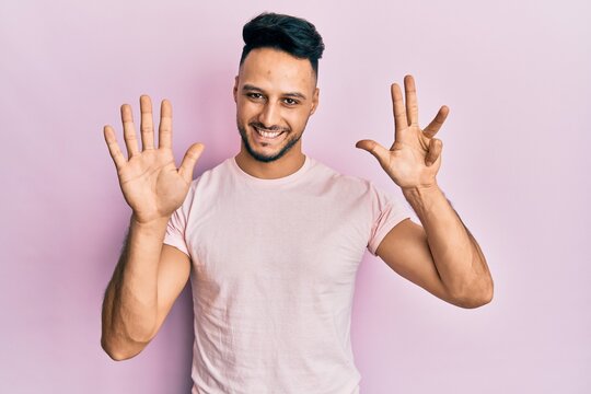 Young arab man wearing casual clothes showing and pointing up with fingers number nine while smiling confident and happy.