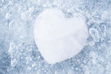 White stone in the shape of a heart frozen in the ice with many air bubbles. Concept of heart disabled to love, feel emotions