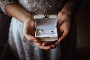 the bride holds a box with wedding rings