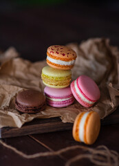 Macarons cakes lie in a stack on a dark background