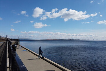Obraz premium Fisherman with a fishing rod fishing on the city promenade in early spring.