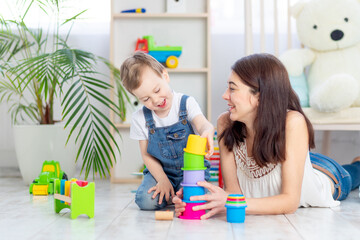 mom and baby boy play at home with educational toys in the children's room. A happy, loving family.