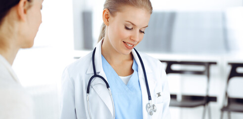 Woman - doctor consults her female patient while using clipboard and medication history record. Medicine concept