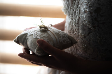 the bride holds in her hands a pillow with wedding rings