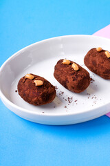 Kartoshka cake on the ceramic plate on colorful background. Russian potato-shaped dessert