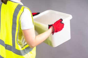 Warehouse worker holds a box. Woman worker. Concept - girl works in a warehouse. She is engaged in...