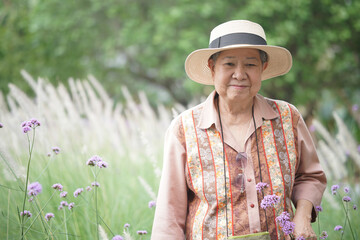 asian old elderly elder woman resting relaxing in rose garden. senior leisure lifestyle