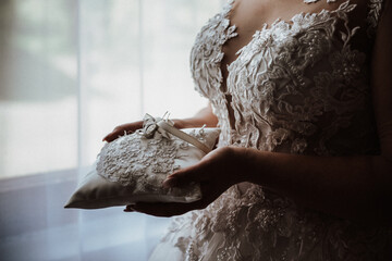 the bride holds in her hands a pillow with wedding rings